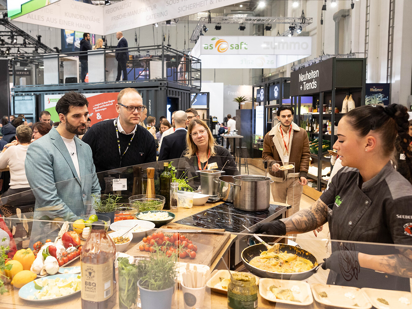 Eine Gruppe von Menschen steht um einen Tisch mit Essen.