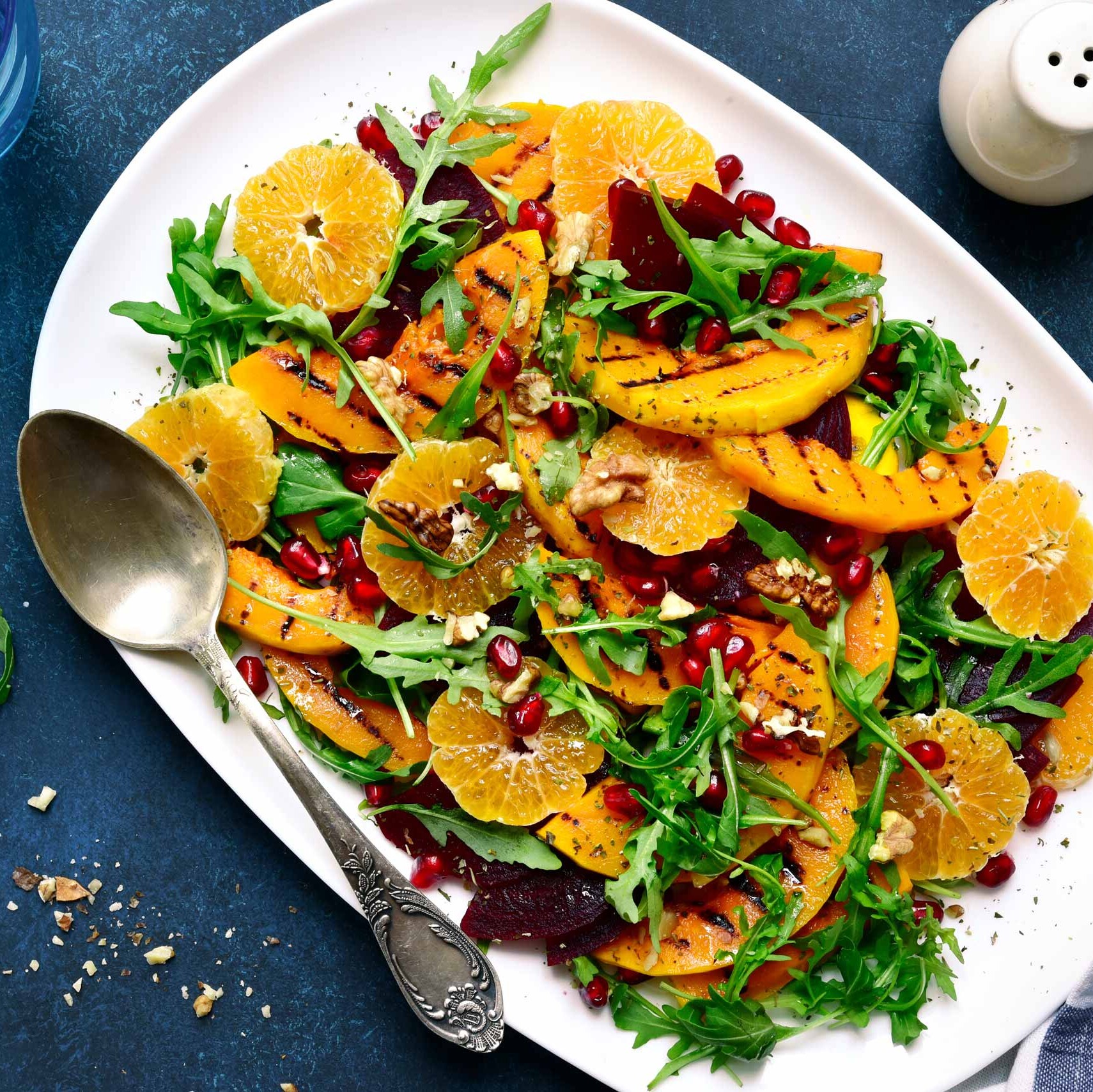 Zitrussalat mit Rucola und Nüssen Orangensalat mit grillierten Mangos, Rucola, Nüssen und Granatapfel