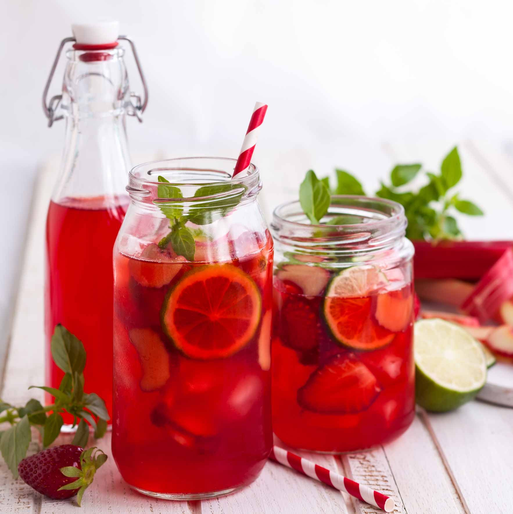 Erdbeer-Rhabarber-Scrub Ein Glas mit roter Flüssigkeit und Trinkhalmen.